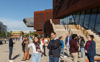 [Translate to English:] Eine diverse Menschenmenge unterhält sich am Campus WU.